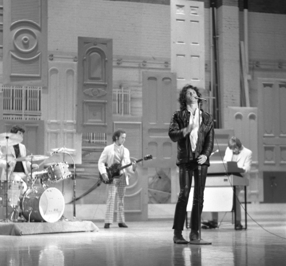 The Doors performing on a television stage with Jim Morrison at the microphone